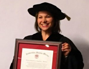 Julie Toskan holding framed copy of honourary PhD
