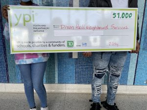 two students holding giant YPI cheque with focus on the cheque