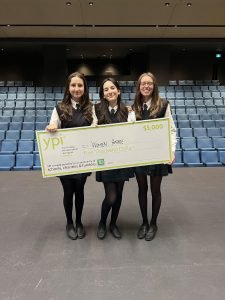 three students in school uniform holding YPI giant cheque